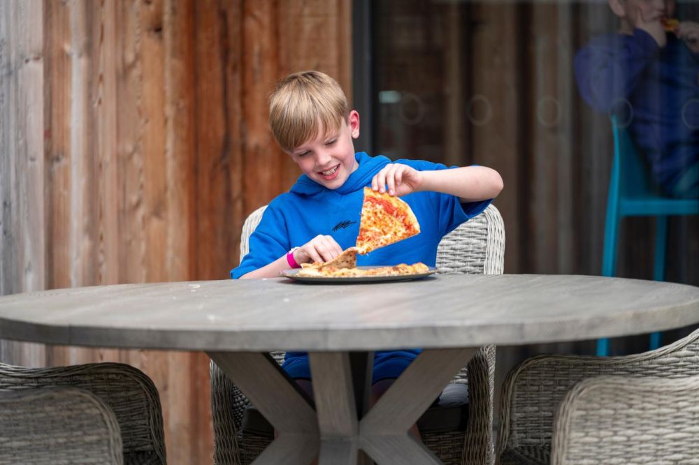 Young boy enjoying our wood-fired pizza