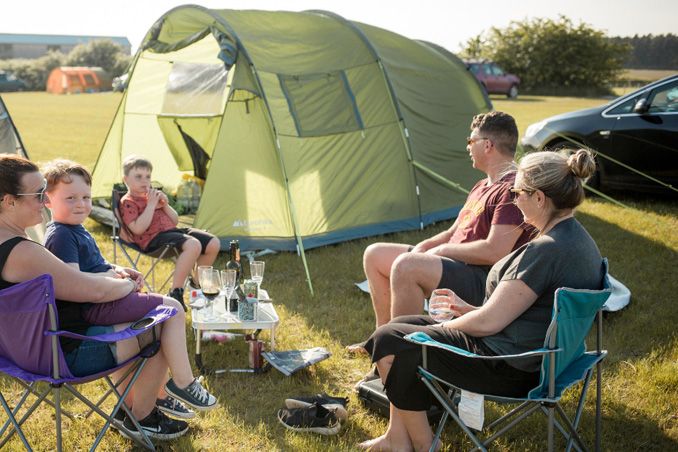 Family around a tent at William's Den