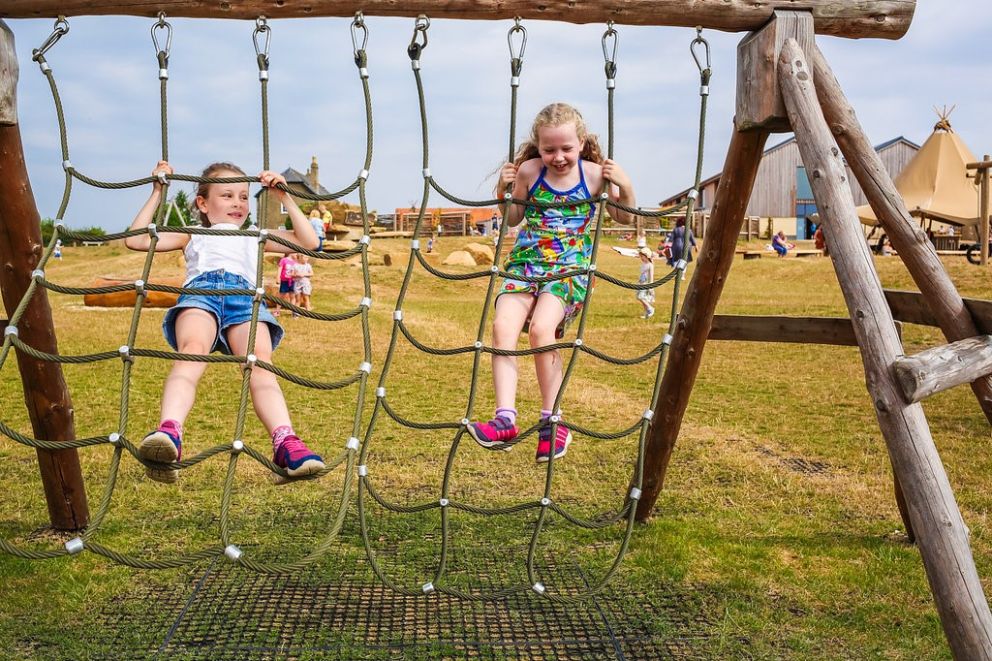 two girls playing on cargo nets