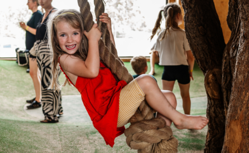 little girl swinging on tree