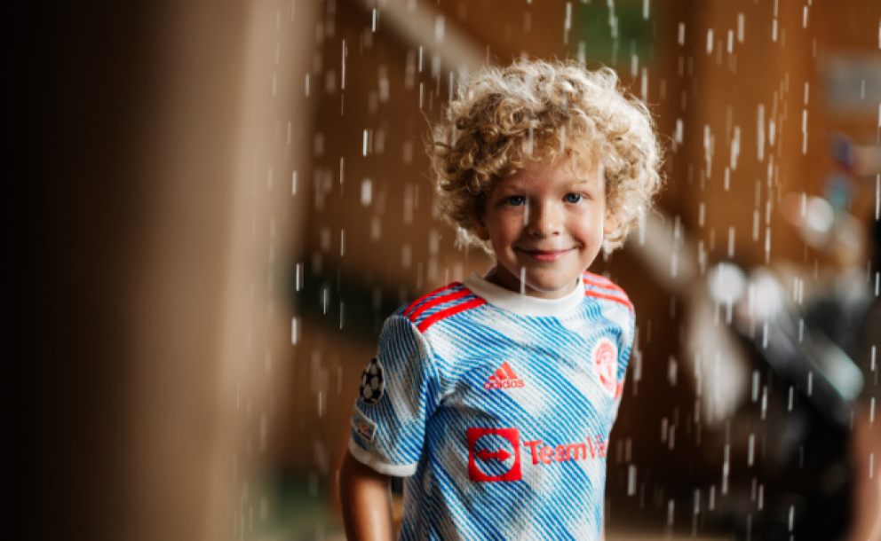 little boy stood under rainmaker