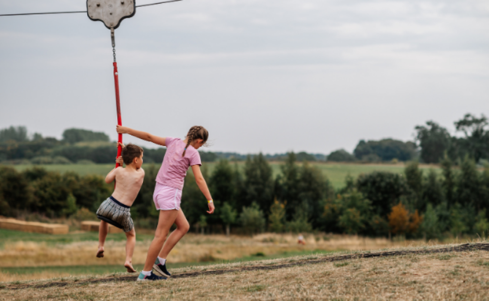 sister pulling brother on zipline