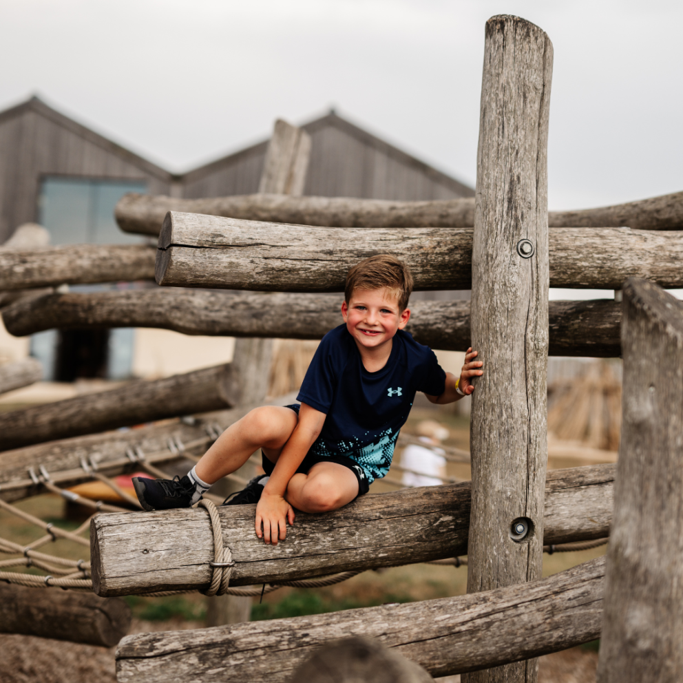 boy sat on climbing frame